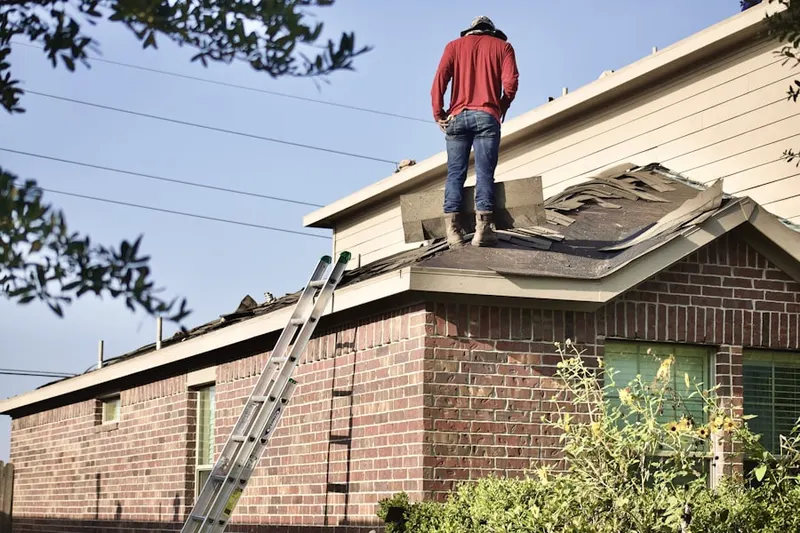 Professional roofer working on a residential roof in Green Manor Village